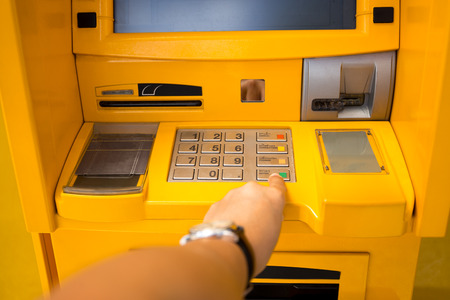 Hand pressing enter button on ATM bank machineの写真素材