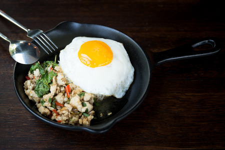 Stir fried chicken with chilli and thai basil on wooden tableの写真素材