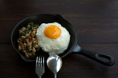 Stir fried chicken with chilli and thai basil on wooden tableの写真素材