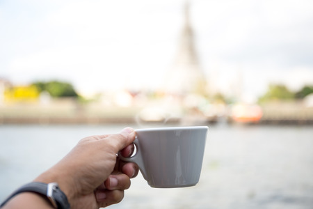 Man is holding a cup of  fresh coffee in the morningの写真素材