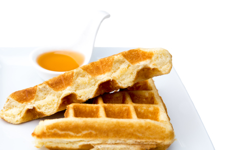 Waffle with honey in white plate isolated on white backgroundの写真素材