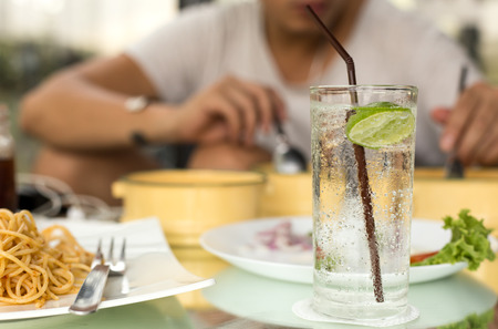 Man having glass of fresh sparkling mineral water with his dinnerの写真素材