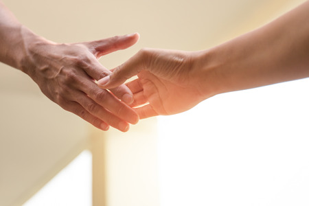 Help Concept Hands reaching out to help together in with sunlightの写真素材