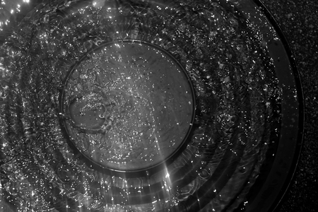 Water splash from rain drop over the black cap in black and white high contrastの写真素材
