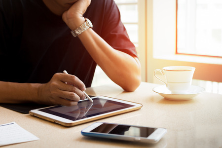 Interior design man working on tablet with coffee cup and cell phone on the tableの写真素材