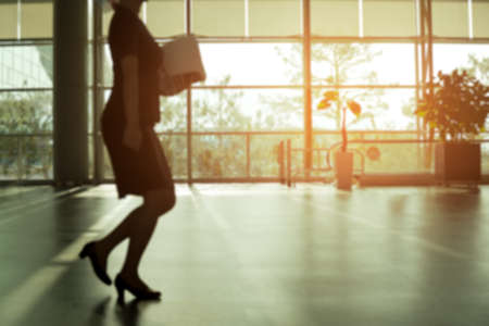 Blurred concept woman walking in airport hall in sunlight in the morningの写真素材