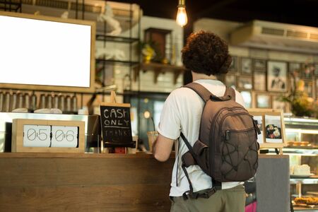 Traveler with rucksack waiting at counter in coffee shopの写真素材
