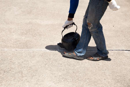 Worker is pouring asphalt for road repair in day timeの写真素材