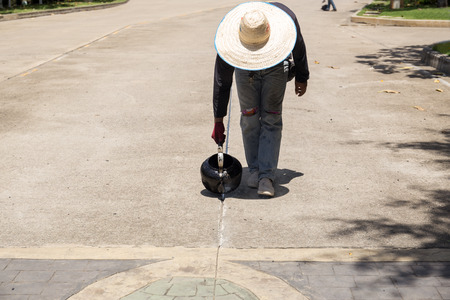 Worker is pouring asphalt for road repair in day timeの写真素材