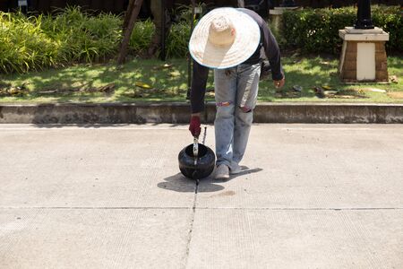 Worker is pouring asphalt for road repair in day timeの写真素材