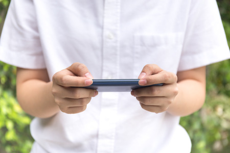 Young people using cell phone reading message outdoorの写真素材