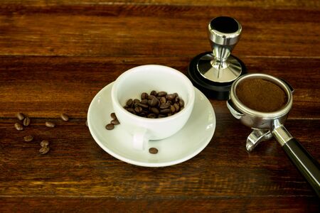 Concept and idea cup with coffee beans and and coffee ground on wooden tableの写真素材