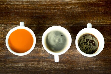 Concept and idea cup of coffee and tea line up on wooden table top viewの写真素材