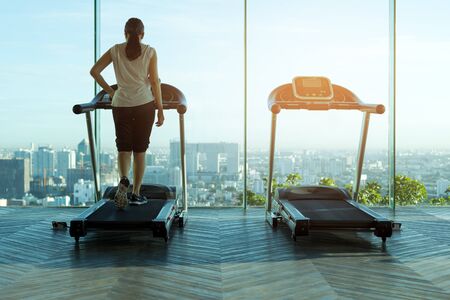Woman walking on a treadmill exercise in the gym in the morningの写真素材