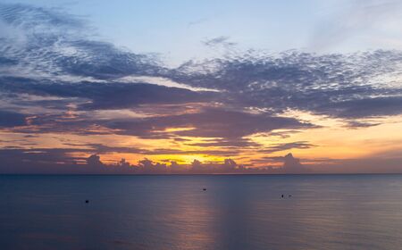 Top view sunrise over ocean with fishing boat and colorful sky cloudの写真素材