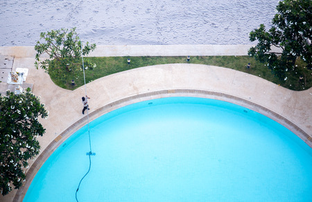 Top view of man cleaning swimming pool with Vacuum cleanerの写真素材