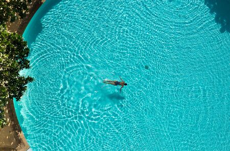 Asian woman swimming  in the pool view from above minimal conceptの写真素材