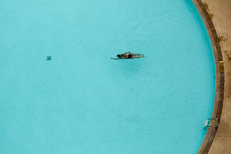 Asian woman swimming in the pool view from above minimal conceptの写真素材