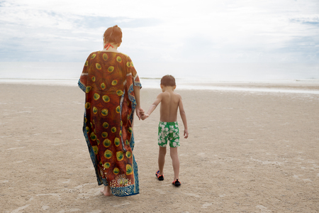 Mother and son walking on the beach on vacationの写真素材