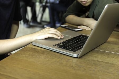 Young university students team up studying with computer in cafeの写真素材