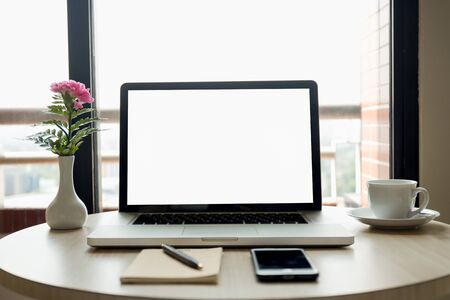Blank laptop screen with flowers and cell phone and coffee and pen Mock up