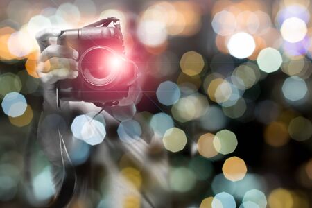Man holding camera with background abstract bokeh light Conceptualの写真素材