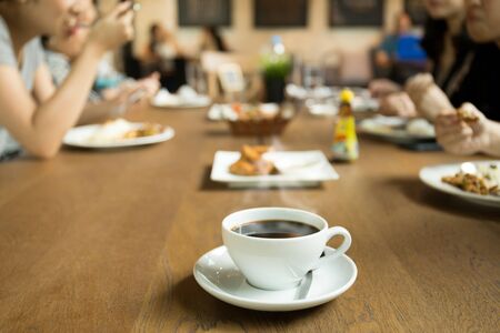 Selected focus cup of coffee with family dinner time on the tableの写真素材