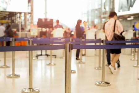 Passengers walking through check-in line at the airport on vacationの写真素材