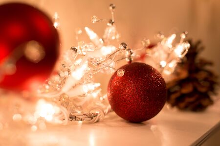Shot in low light with high ISO Christmas ball with christmas lights decoration on top of fire placeの写真素材
