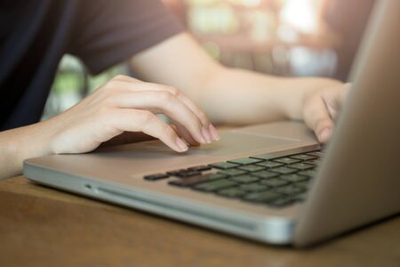 Woman working on laptop in the cafe with sunlightの写真素材
