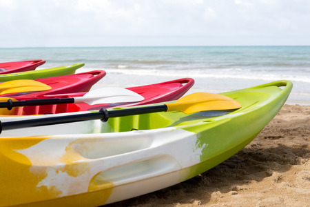 Colorful sea kayaks on sand beach with oceanの写真素材