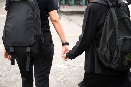 Daughter and mother hands holding hands crossing streetの写真素材