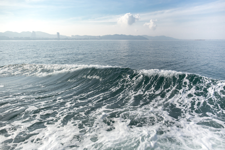 Deep blue ocean wave with mountain and sky  in backgroundの写真素材