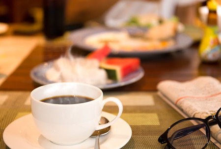 Breakfast with coffee and the newspaper with fresh fruit saladの写真素材