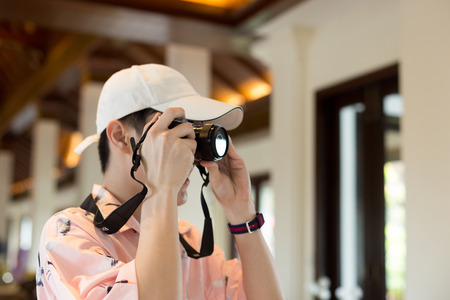 Young tourist taking picture with compact camera on vacation