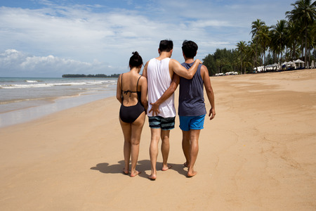 Threesome love friends of two men and one woman on the beach. Concept Love gayの写真素材