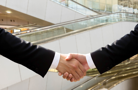 Business hand shake agreement in office buildingの写真素材