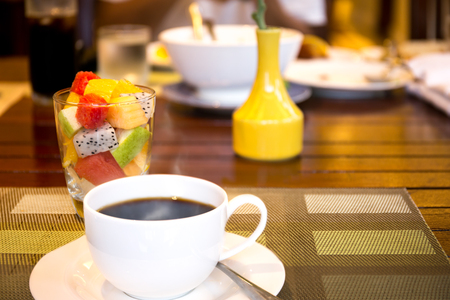 Healthy breakfast fruit salad and  cup of coffee on the tableの写真素材