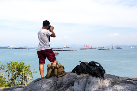 Unidentified photogragpher taking pictures of ocean with ship on the cliffの写真素材