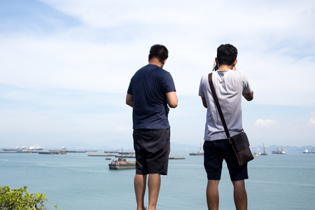 Unidentified photogragpher taking pictures of ocean with ship on the cliffの写真素材