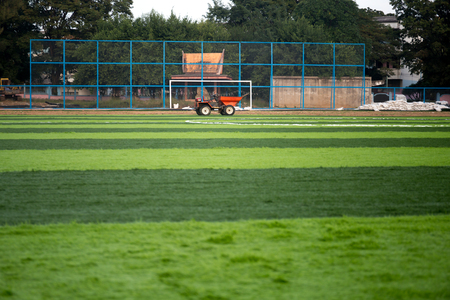 Orange truck with Artificial bright and dark green grass on soccer stadiumの写真素材