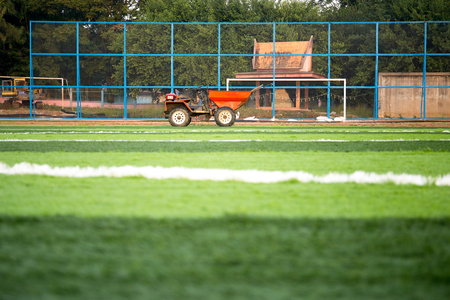Orange truck with Artificial bright and dark green grass on soccer fieldの写真素材