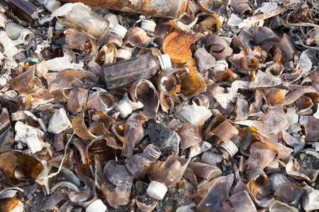 Broken glass bottles and can in garbage yardの写真素材