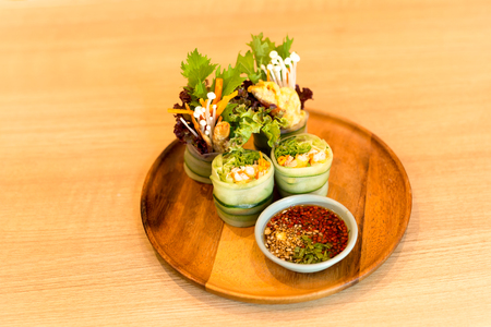 Salad roll of vegetable salad on wooden plate with Thai sauce fusion foodの写真素材