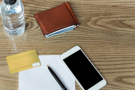 Conceptual credit crad and cell phone with pen and paper and wallet on wooden tableの写真素材