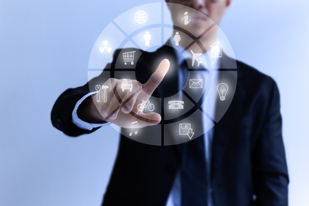 Businessman touch digital icons on the holographic interfaceの写真素材