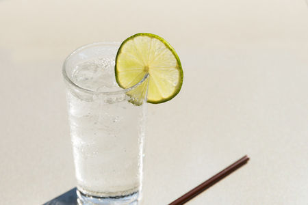 Glass of fresh drinking water with slice of limeの写真素材