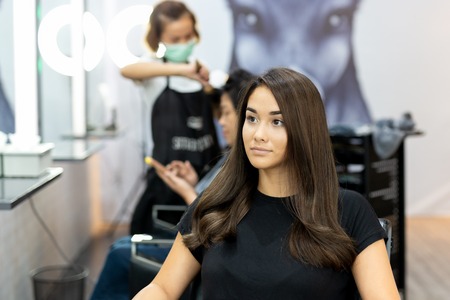 Portrait of beautiful mixed race young girl with long smooth hair in salon.の写真素材