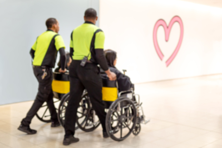 Blurred concept caretaker pushing elderly people in wheelchair in the airportの写真素材