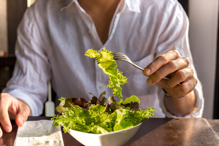 Men having a vegetables salad in the morningの写真素材